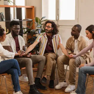 Group Sitting in Circle Holding Hands 